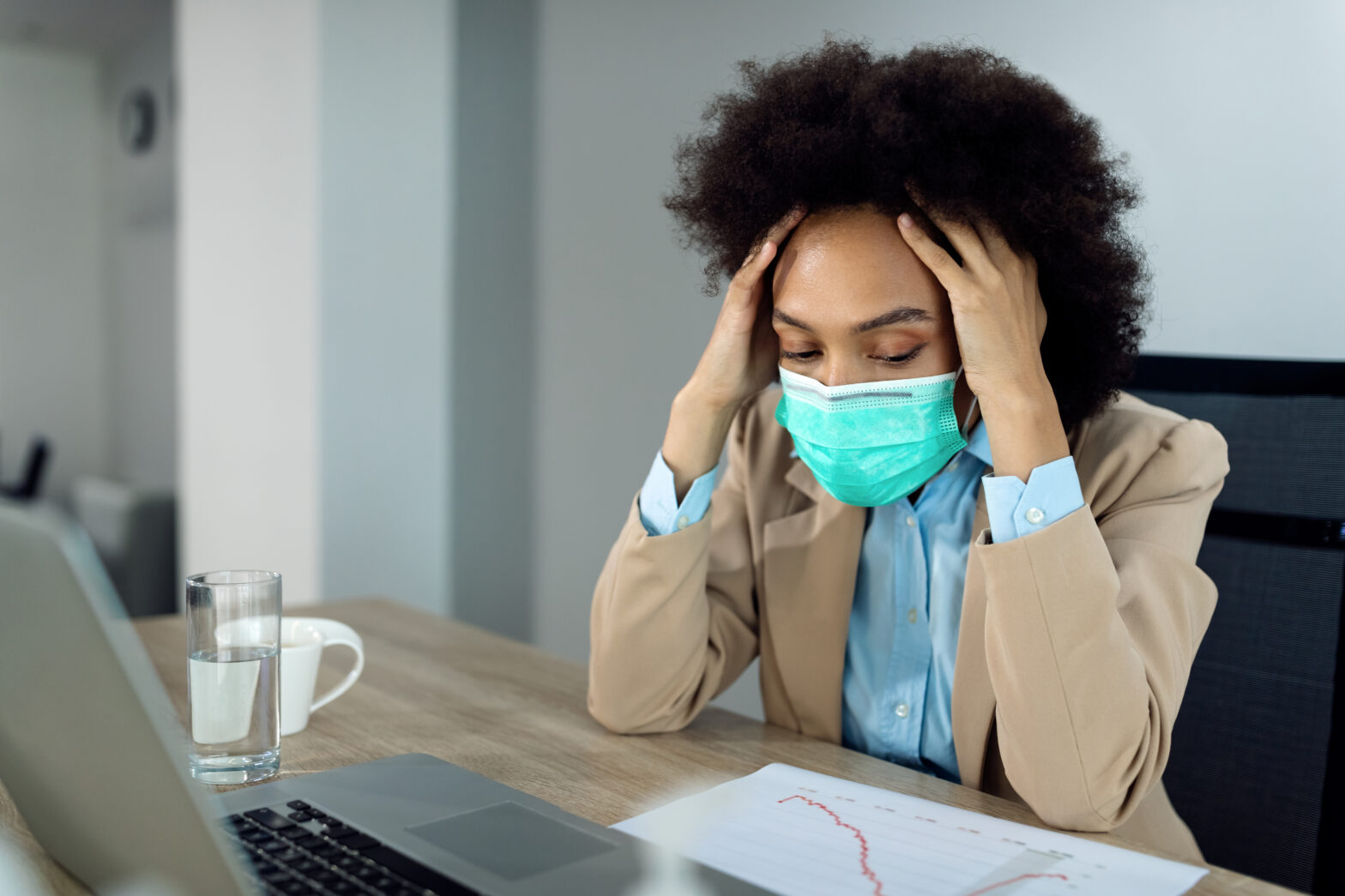 Black businesswoman feeling stressed out while working in the office during coronavirus pandemic.