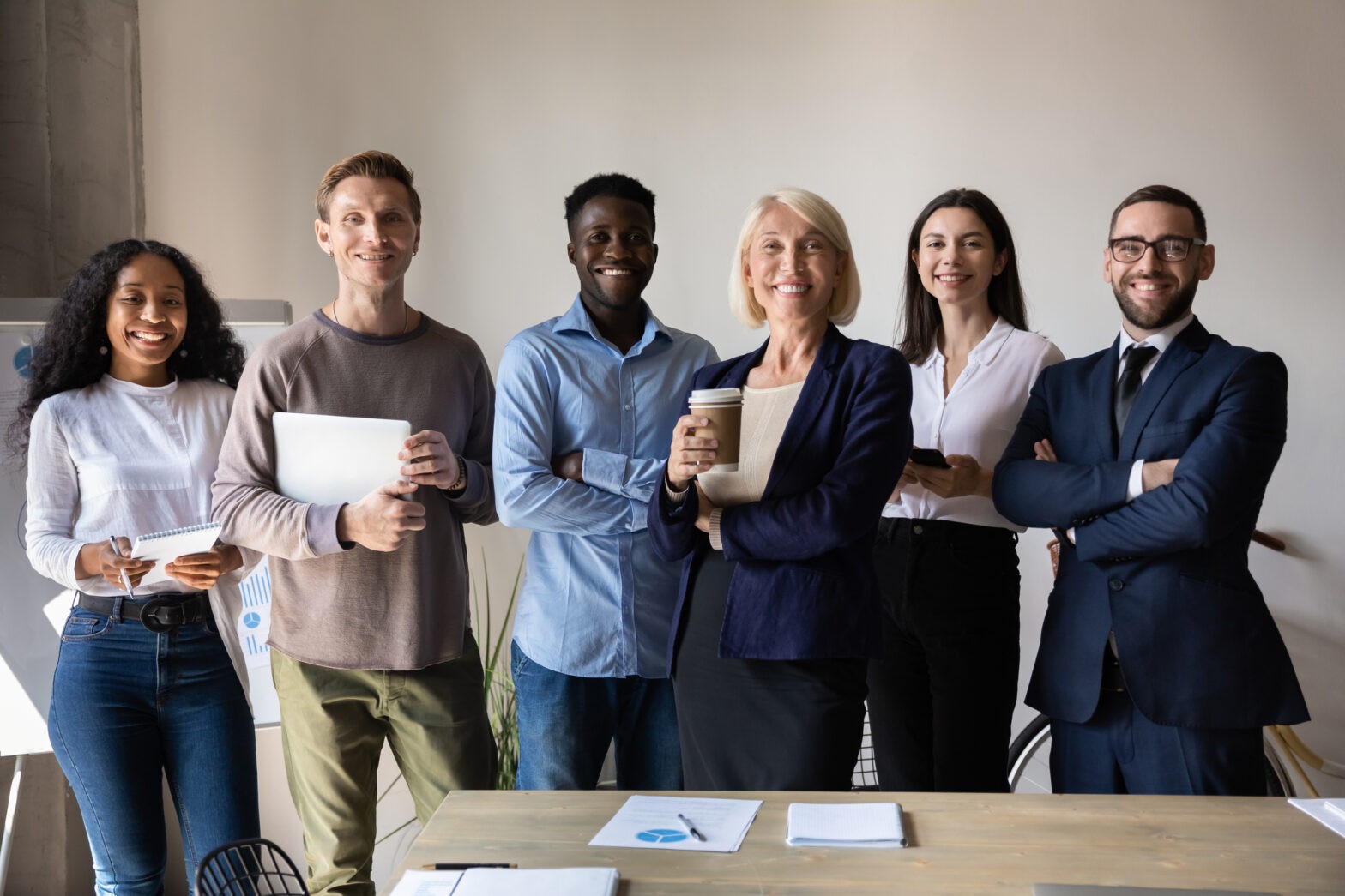 Happy confident diverse businesspeople stand together in office, team portrait