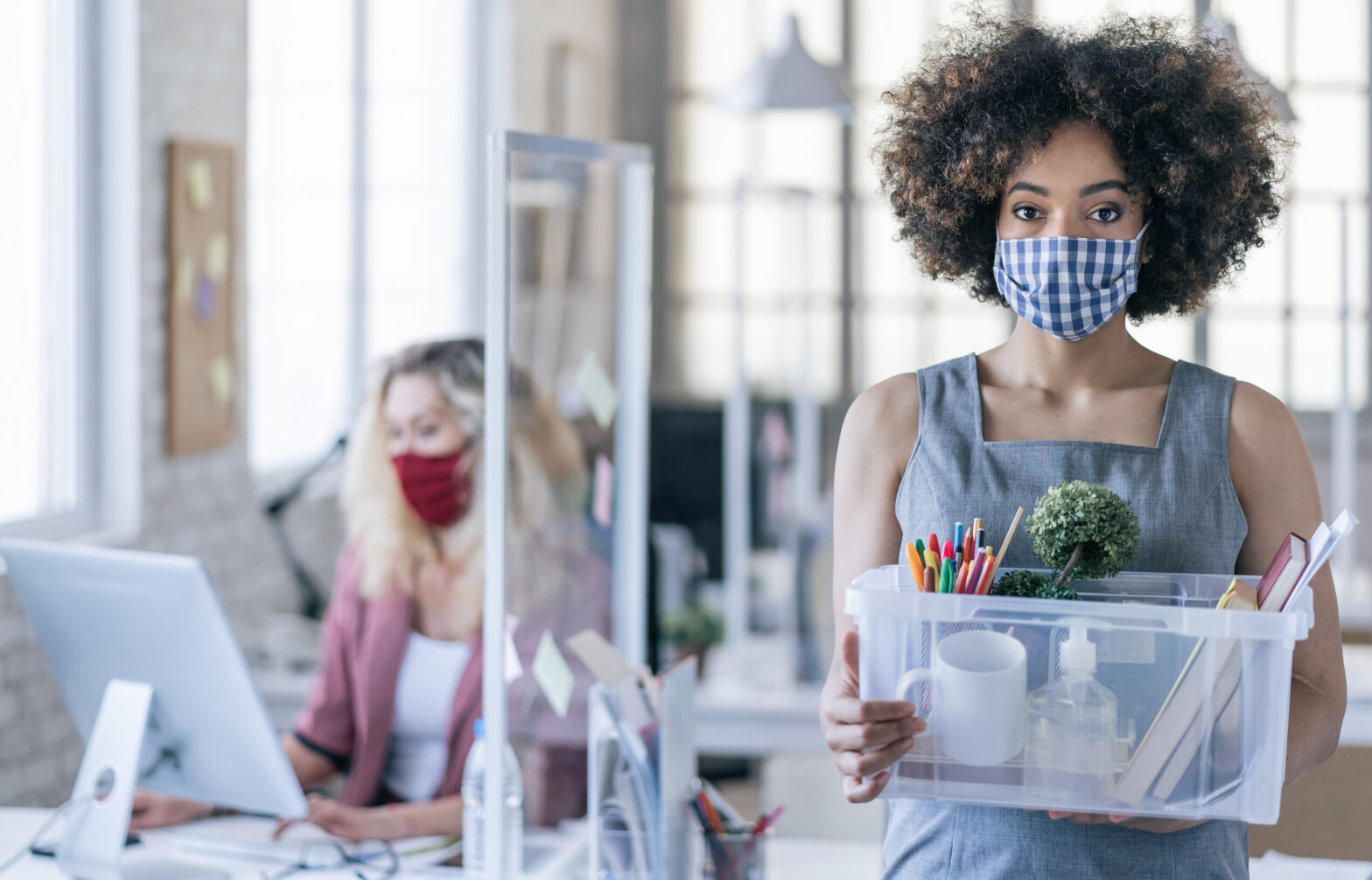 Businesswoman with protective face mask quits job due to limiting workplaces in office, during Covid-19
